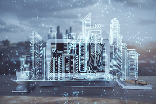 Desktop computer background in office and big town buildings hologram drawing. Double exposure. Smart city concept.