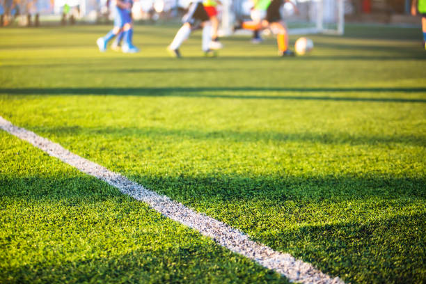 istock Selective focus to white lines on green artificial grass football fields with kid soccer player. 1286414207