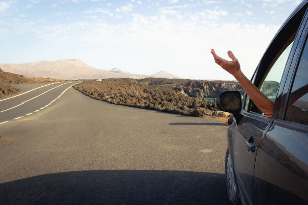 istock Woman in car pulled over on volcanic island road 1286415056