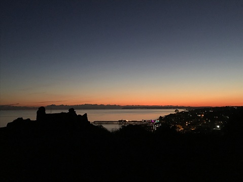 Night views of Hastings castle in silhouette and Hastings pier.