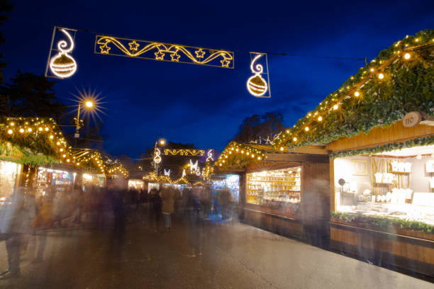 soft focus concept picture of Christmas fair long exposure photography with walking people near market counters in cozy and warm evening time with lamps lights and decoration festive environment space soft focus concept picture of Christmas fair long exposure photography with walking people near market counters in cozy and warm evening time with lamps lights and decoration festive environment space long exposure winter crowd blurred motion stock pictures, royalty-free photos & images