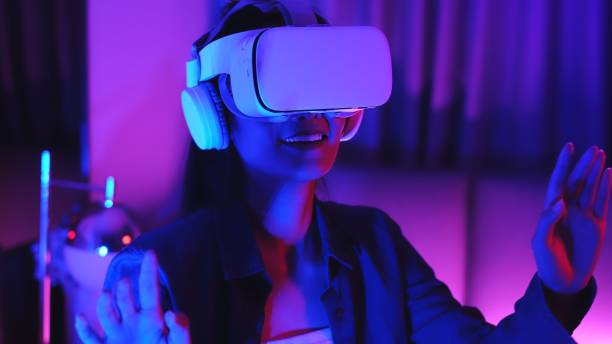 istock Young asian woman is using virtual reality headset. Neon light studio portrait. Concept of virtual reality, simulation, gaming and future technology.Asian woman play game in bedroom. 1286423113