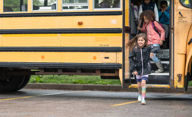 A diverse group of kids run off the school bus.