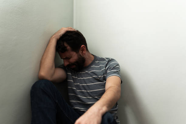 istock Grieving man in his 30s sitting alone on the floor 1286432409
