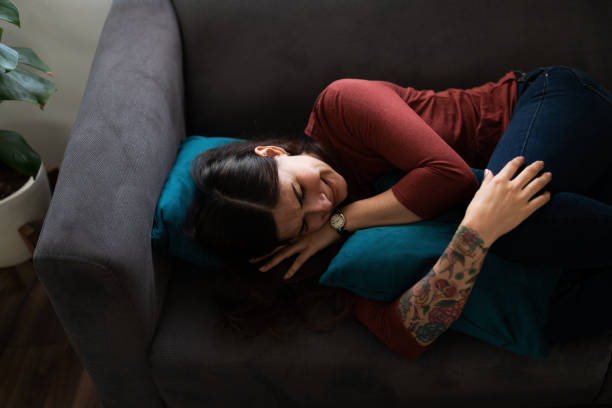 istock Woman in her 20s sobbing and lying on the sofa 1286432541