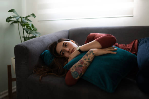 istock Woman looking depressed and lying on the couch 1286432552