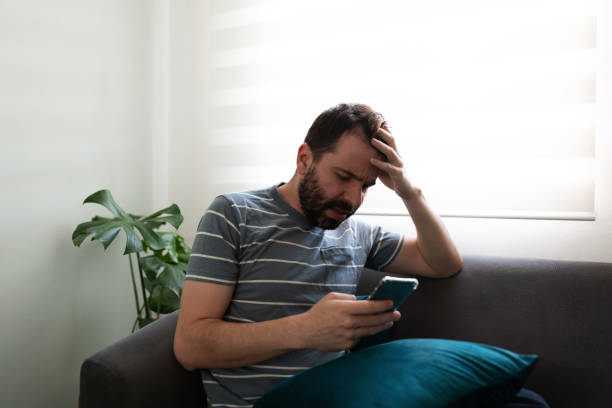 istock Adult man using his cellphone with a somber expression 1286432734