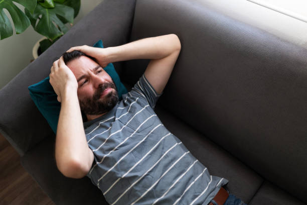 istock Upset man looking worried and lying on the sofa 1286432783