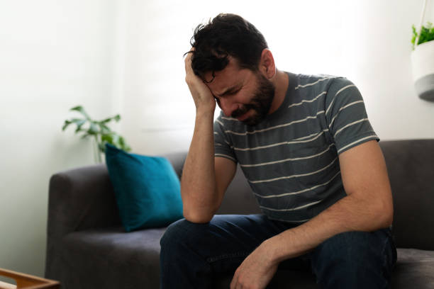 istock Sad adult man crying alone on the couch 1286432799