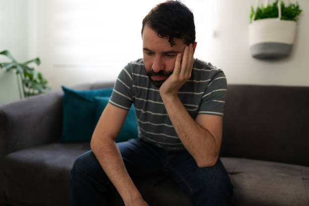 istock Depressed adult man sitting on the couch 1286432814
