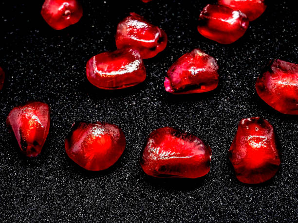 istock red grains of ripe pomegranate on a black background, macro 1286435357