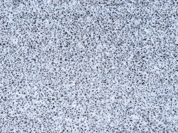 istock asphalt road covered with first snow. winter textured background 1286443070