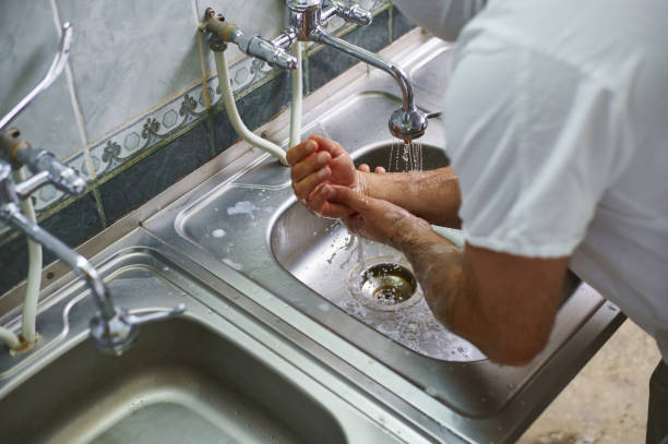 istock A surgeon in a white uniform washes the soap solution off his hands with water. Hand treatment before surgery. 1286443947