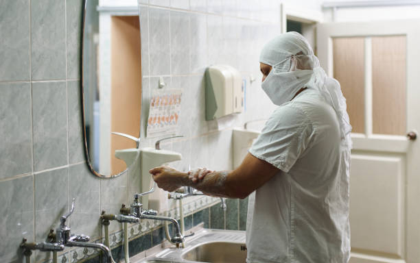 istock A surgeon in a white uniform and a protective mask treats his hands with soapy water. Hand treatment before surgery. 1286443957