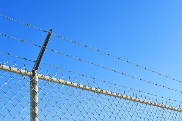 istock Chain Link and Barbed Wire Fence 1286444792