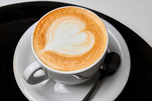 istock A cup of coffee. Latte with heart pattern in a white cup on black-white background 1286447236