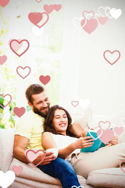 Composite image of valentines heart design Valentines heart design against man holding a cup of coffee while woman reading book book heart shape valentines day copy space stock pictures, royalty-free photos & images