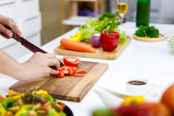 istock Chef uses knife to cut tomato. 1286448281