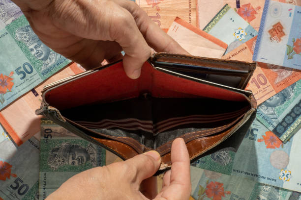 istock A man shows the empty wallet on the banknote background 1286449943