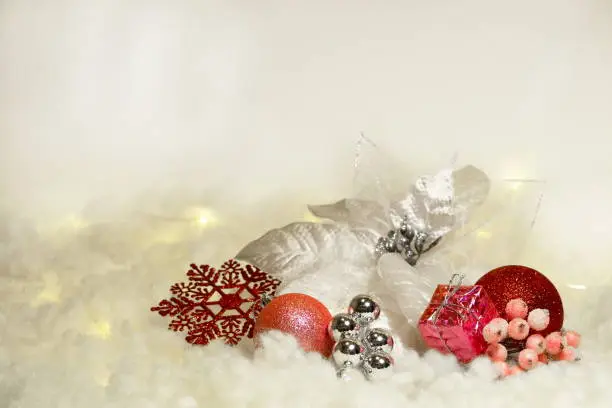 A beautiful composition in the snow, consisting of a rogen star and Christmas tree decorations in red, silver and white colors