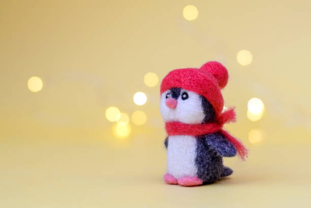 istock Toy wool penguin on a yellow background with bokeh 1286455165