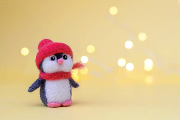 istock Toy wool penguin on a yellow background with bokeh 1286455210