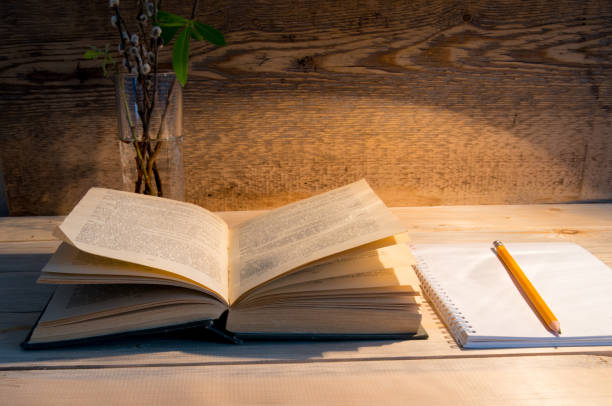 istock A book with a notebook, a pencil, a lamp, a glass and willow branches on the table. 1286457099