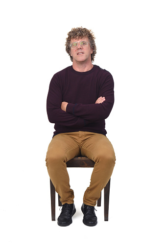 man sitting on white background, arms crossed