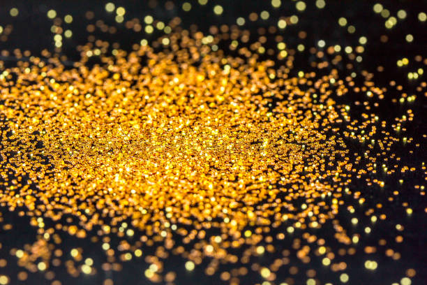 istock Gold glitter powder sparkling on black background. 1286458145