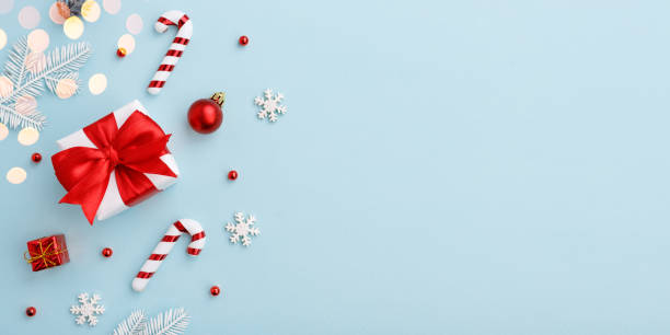 istock Christmas gift box with red bow and decorations on pastel blue background 1286463746