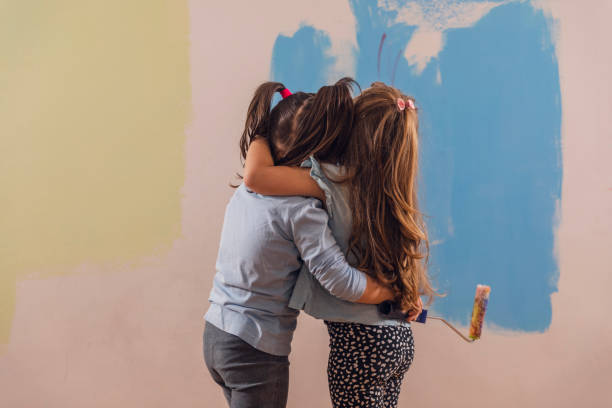 istock Girlfriends hugging after painting a wall together 1286464709