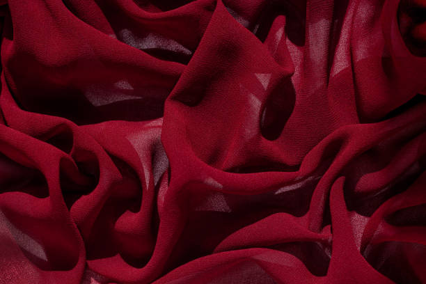 istock Smooth elegant burgundy chiffon fabric abstract background. Dark red wine silk luxury cloth texture light surface design 1286465121