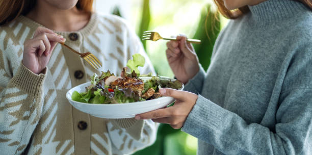 istock women holding and eating chicken salad together 1286466155