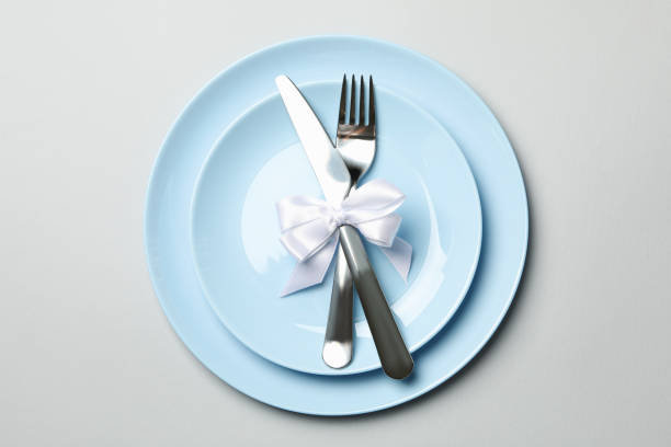 istock Plates with cutlery and bow on white background, top view 1286466216