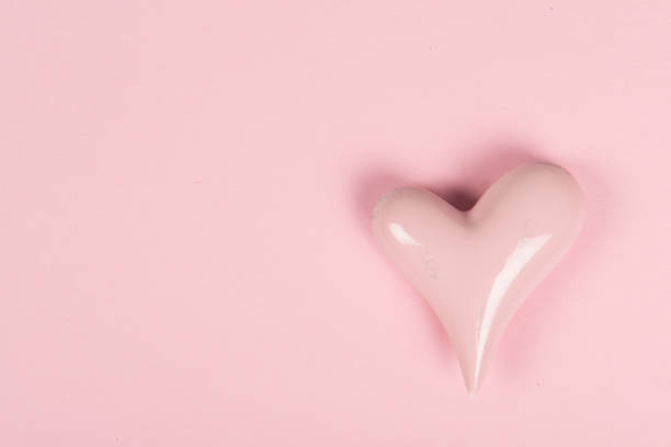 istock Pink glossy heart shaped stone on a pink background with space for copy 1286466295