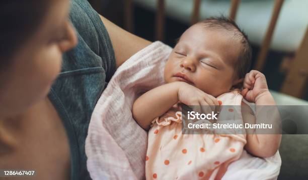 Newborn Baby Sleeping In Safety While Mother Is Holding And Smiling At Her Stock Photo - Download Image Now