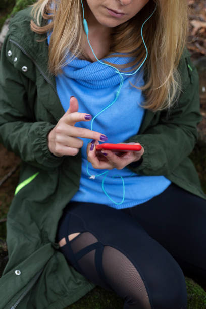 istock Pretty woman is using her smart phone in the forest 1286469847
