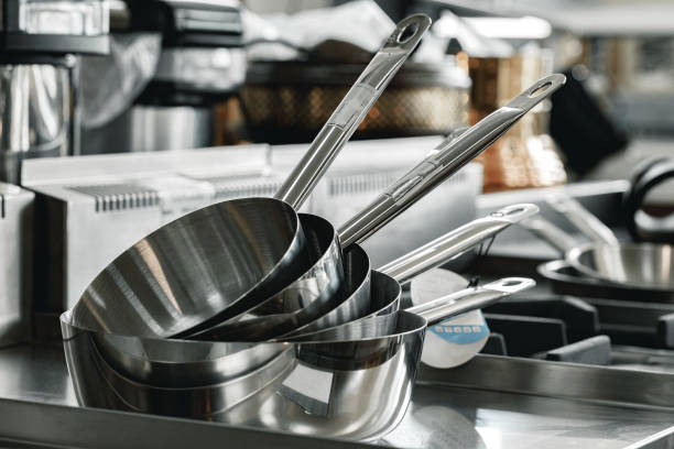 istock Stacked industrial metal cooking pots on proffesional kitchen 1286470485