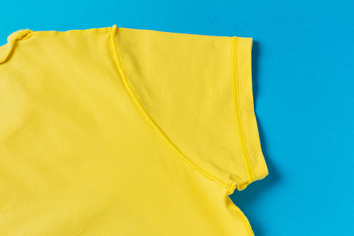 Yellow cotton T-shirt with short sleeves turned inside out. Material texture