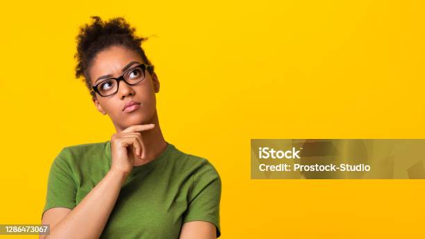 Black Lady In Eyeglasses Thinking About Question Touching Chin Stock Photo - Download Image Now