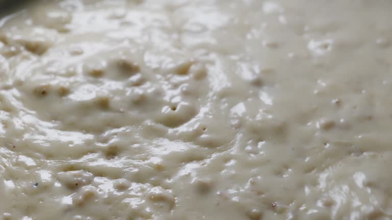 Preparation of traditional bechamel for homemade meat croquettes: milk, onion, minced Iberian pork and nutmeg. 4K high definition, smooth movements.