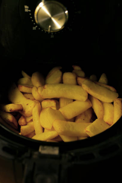 imagen de papas fritas sin cocinar / patatas fritas gruesas cocinadas en freidora de aire, alternativa más saludable a la cocina de aperitivos - french fries fast food french fries raw raw potato fotografías e imágenes de stock