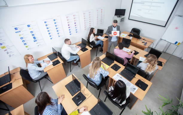 istock Driving instructor holding and showing a STOP sign representation on paper in the classroom 1286477554