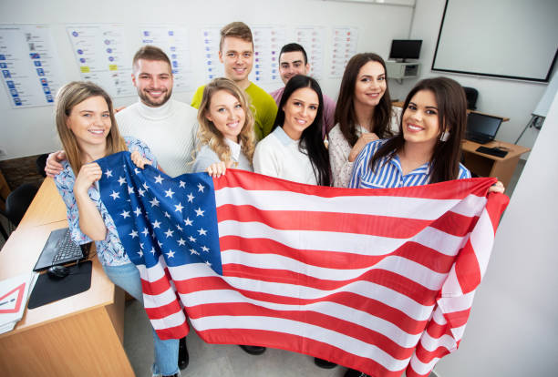 istock Group of students holding an American flag in the classroom 1286477582