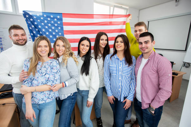 istock Group of students in the classroom holding American flag 1286477961