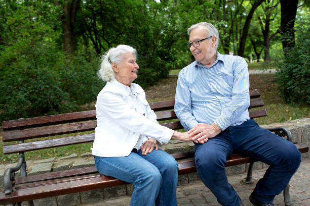 istock Elder couple holding hands on the park bench 1286479121