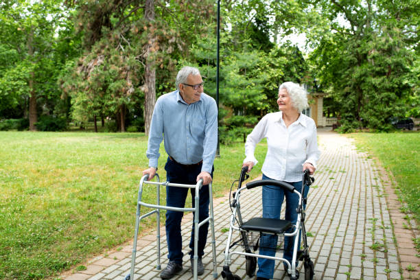 istock Senior citizens walking through the park with walking aid 1286479347