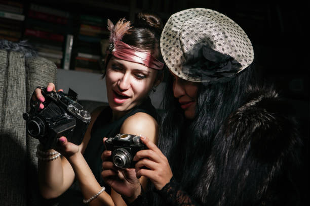 Lady photographers are inspecting old-fashioned cameras and laughing at the pictures