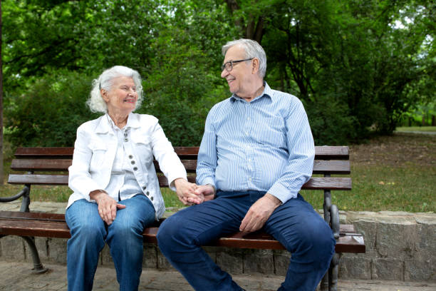 istock Senior couple sitting on the park bench 1286479624