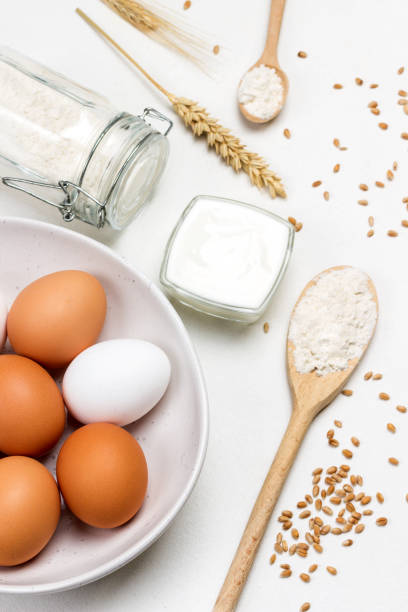 istock Eggs in white bowl. Flour in wooden spoon and in jar. 1286479646